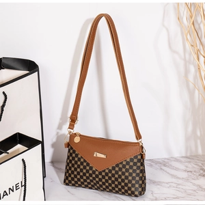 Detail of crossbody square bag featuring brown texture with golden metal triangle clasp