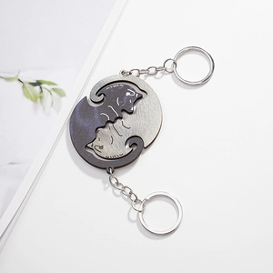 Close-up of black and silver cat couple keychains forming a Yin Yang circle puzzle