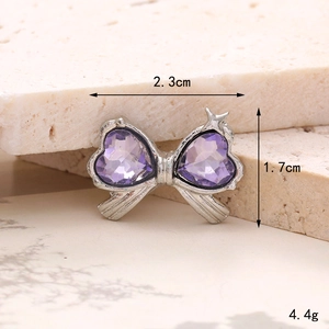 Detail showing a silver bow charm with purple heart crystals, 2.3cm wide and 4.4g weight