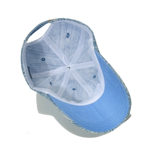 Détail des coutures internes et des bandes de support blanches de la casquette en denim
