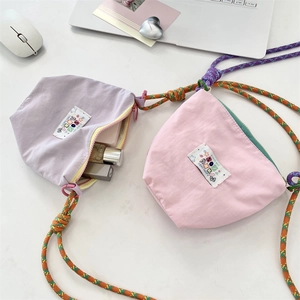 Flat lay of macaron-colored crossbody bags with woven ropes and interior storage detail