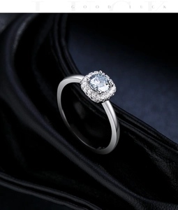 Macro shot of 50-carat grey moissanite ring with square halo setting on black leather
