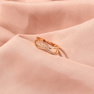 Detailed view of rose gold safety pin ring with cubic zirconia on silk background