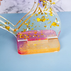 Dettaglio macro della base in resina epossidica con foglia d'oro e glitter rosa sfumati