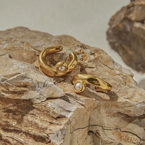 Macro di orecchini a clip dorati con perla su pietra per evidenziare il metallo