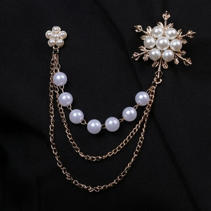 Elegant gold layered chain brooch with pearl snowflake and floral charms on black fabric