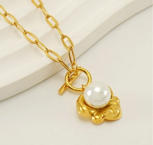 Dettaglio dell'elegante collana in titanio dorato con perla e chiusura a levetta OT