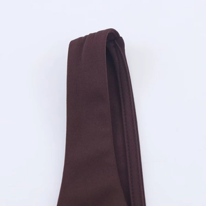 Detail of dark brown knitted mesh stitching and fabric texture on a women's dress
