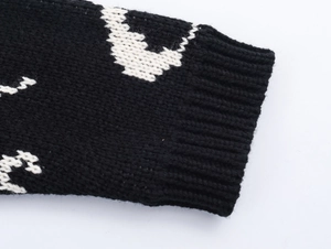 Detail of ribbed cuffs and thick black and white knitted fabric texture on the sweater