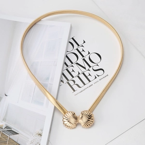 Detailed view of elastic gold metal belt featuring a stylish double shell buckle design