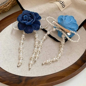Detailed macro view of fabric flower hair clips with elegant long pearl tassel chains