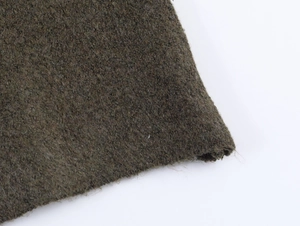 Dettaglio ravvicinato del tessuto in misto lana verde oliva scuro e trama delle fibre