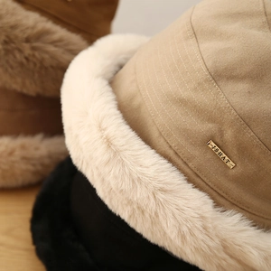 Detailed shot of plush winter bucket hats with faux fur trim and gold metal logo plates