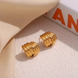 Detail view of gold-plated 18K triple layered textured earrings with a crisscross design