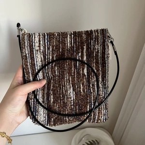 Macro detail of retro ethnic striped woven fabric texture on a compact crossbody bag