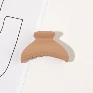 Detailed view of matte beige claw clip showing ergonomic curved design and textured surface