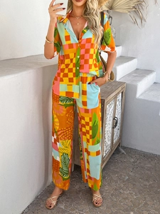 Detail of vibrant tropical leaf print and orange-blue geometric patterns on summer set