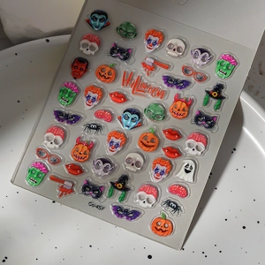 Macro shot of 3D Halloween nail stickers featuring skulls, pumpkins, and bats for DIY art