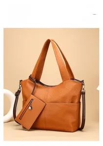 Detailed texture of orange-brown elephant-pattern leather tote bag with a small pouch