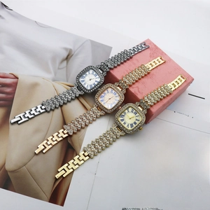 Three elegant square dial quartz watches with diamond straps displayed on a magazine