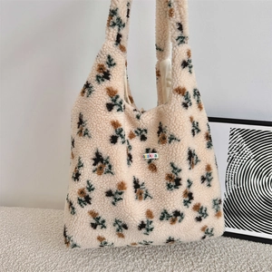 Detailed macro view of soft cream floral plush tote bag with colorful logo patch