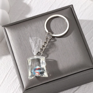 Macro shot of creative resin tropical fish water bag pendant with silver keychain ring