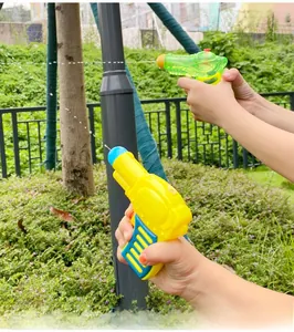 Action shot of children's mini water gun spraying a stream in an outdoor park setting