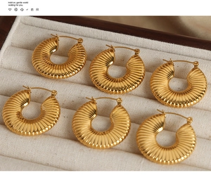 Detailed view of 18K gold plated titanium steel hoop earrings with pleated texture in a box