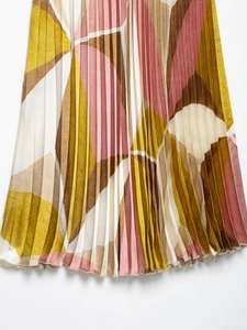 Detail of colorful geometric print pleated midi skirt with sharp accordion fold texture