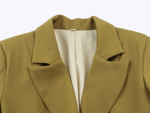 Close-up of olive green blazer collar showing detailed fabric texture and lapel design