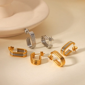 Detail of multi-layer U-shaped titanium steel earrings in gold and silver finishes