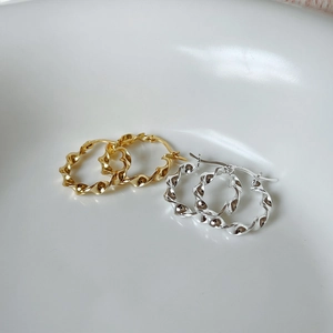 Detail of twisted spiral hoop earrings in silver and gold with S925 hallmark