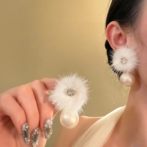 Detailed view of winter pearl earring featuring a white fur ball and faceted crystal gem