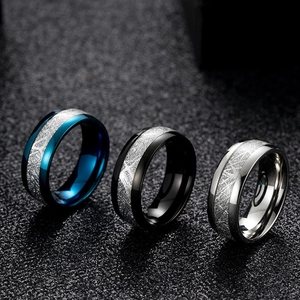 Macro shot of stainless steel rings with carbon fiber textured inlay in blue and black