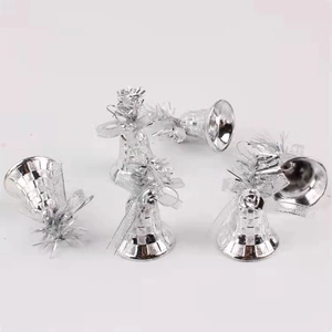 Detail of silver Christmas bell ornaments with festive bows and metallic finish