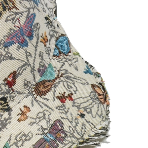 Detail of high-density butterfly embroidery on beige baseball cap with frayed edge finish