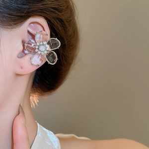 Close-up of zircon crystal flower ear cuff with transparent petals on a model's ear