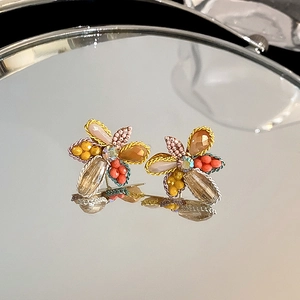 Close-up detail of elegant handmade crystal flower stud earrings with colorful beadwork