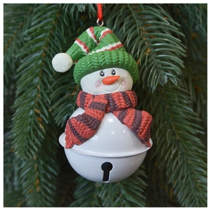 Close-up of a snowman Christmas bell hanging on a green tree branch with knit hat detail