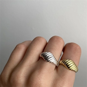 Vista detallada de anillos croissant chapados en oro de 18K y plata en la mano