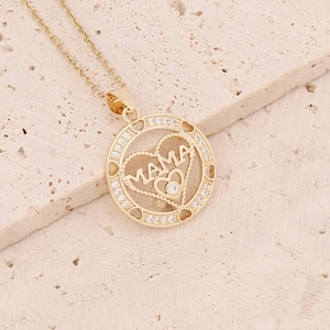 Golden MAMA pendant necklace with pavé cubic zirconia on stone texture background