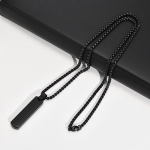 Close-up of black rectangular bar pendant with box chain and lobster clasp on contrast background
