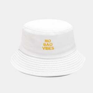 Close-up of yellow 'NO BAO VIBES' embroidery on white cotton bucket hat fabric