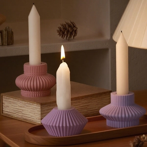 Detailed view of pink and purple striped resin candle holders in a cozy home setting