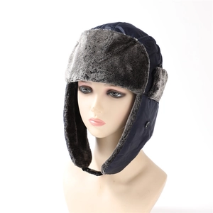 Detail view of quilted blue winter trapper hat with grey faux fur lining and buckle