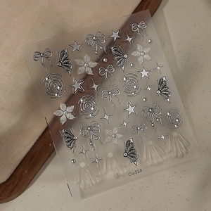Detailed view of nail stickers with silver butterfly, bow, and star patterns, model Co-524
