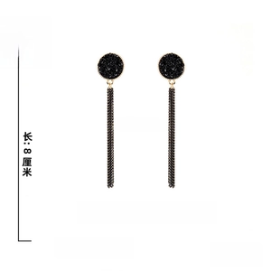 Detail view of black tassel earrings with measurements 8cm length and 1.7cm width