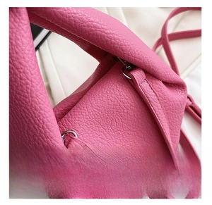 Close-up of bright silver hardware and textured lychee leather on rose pink handbag