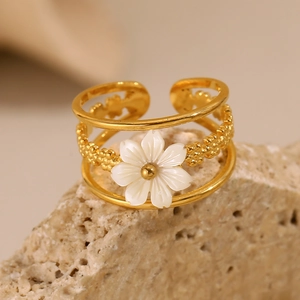Macro view of 18K gold plated flower ring with shell petals on natural stone
