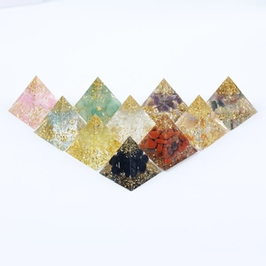 Set of crystal healing pyramids with natural crushed stones and gold foil resin